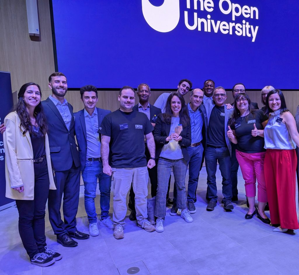 A group photo of a team within KMi. Prof. Miriam Fernandez is front and centre holding her reward